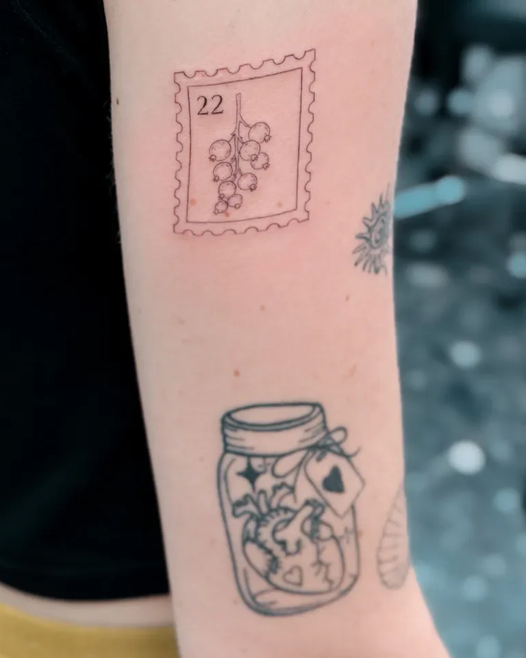 Fine line postage stamp and flower bottle tattoo on the arm