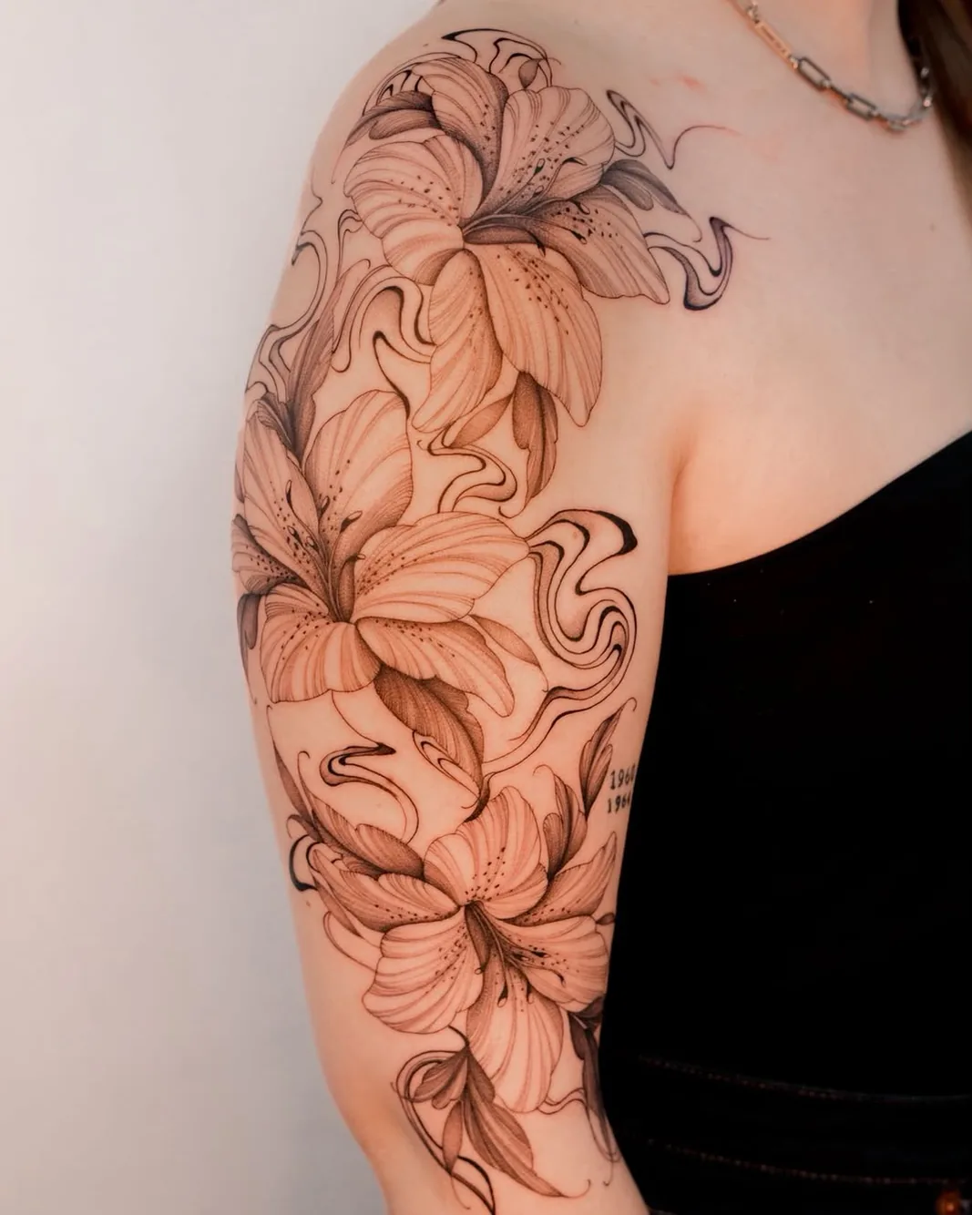 Botanical lilies and smoke half sleeve tattoo on the shoulder and arm