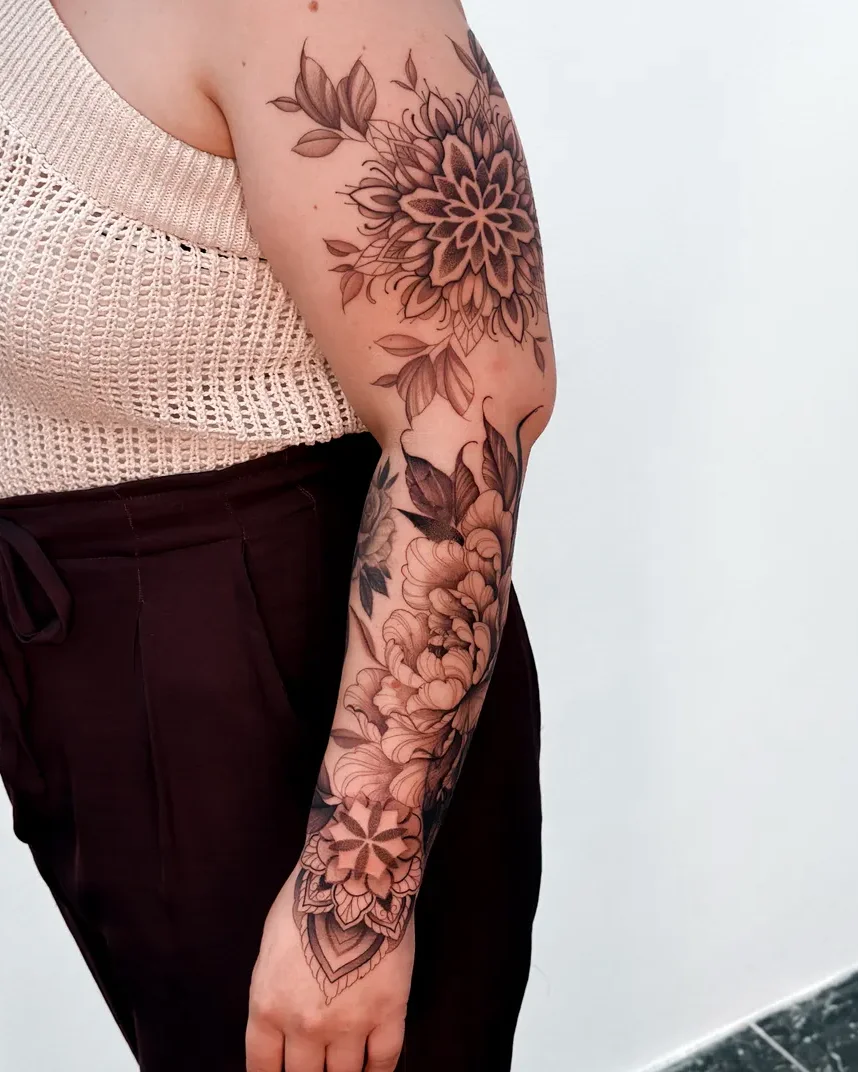 Botanical mandala and flower sleeve tattoo on the arm