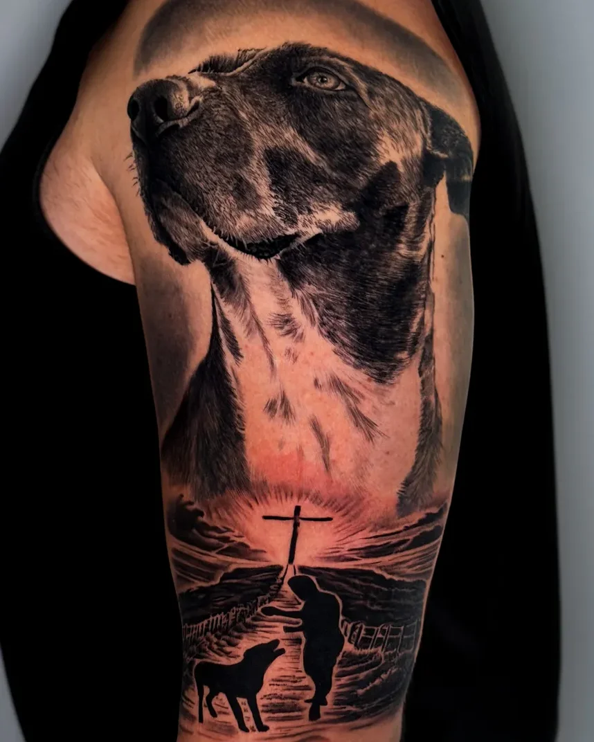 Realism dog portrait and seaside scene tattoo on the upper arm