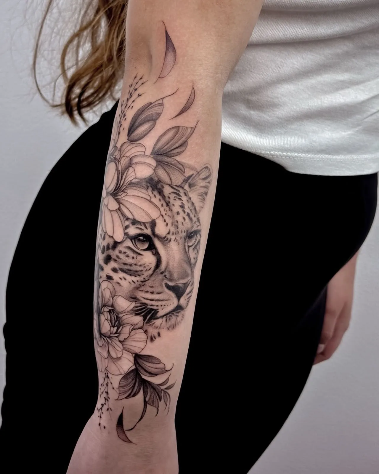 Leopard among flowers on the forearm — tattoo by Hugo Gonzalez, Funchal, Madeira