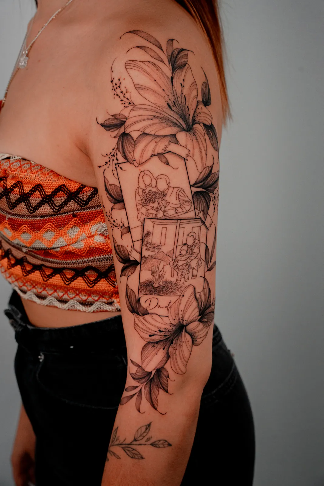 Floral half sleeve with lilies and a framed memory by Hugo Gonzalez