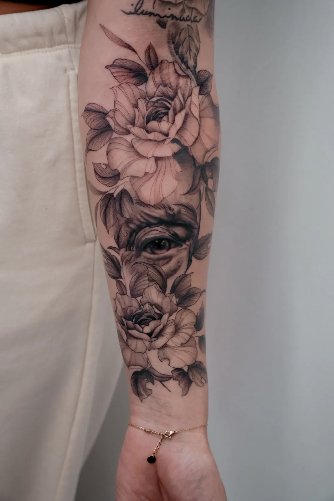 Black and grey roses with a hidden eye on the forearm by Hugo Gonzalez