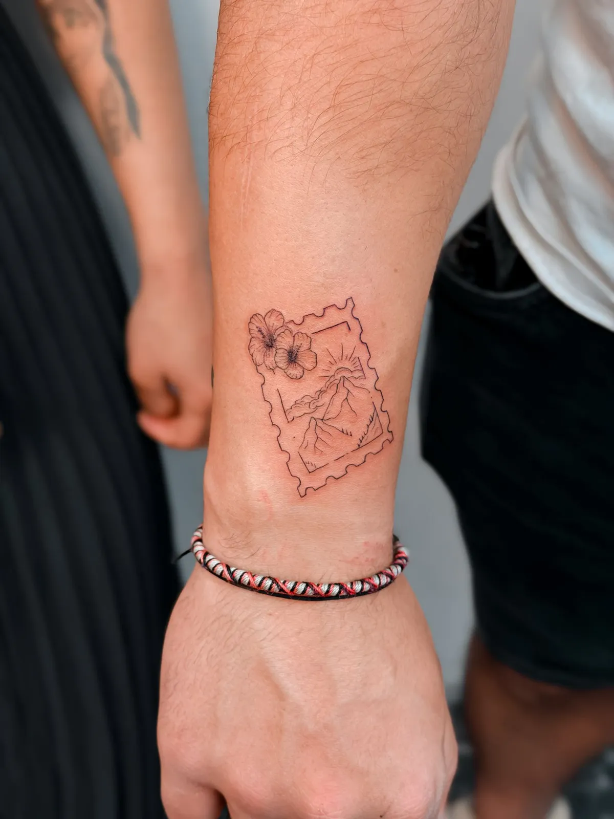 Fine line postage stamp with hibiscus on the wrist by Hugo Gonzalez